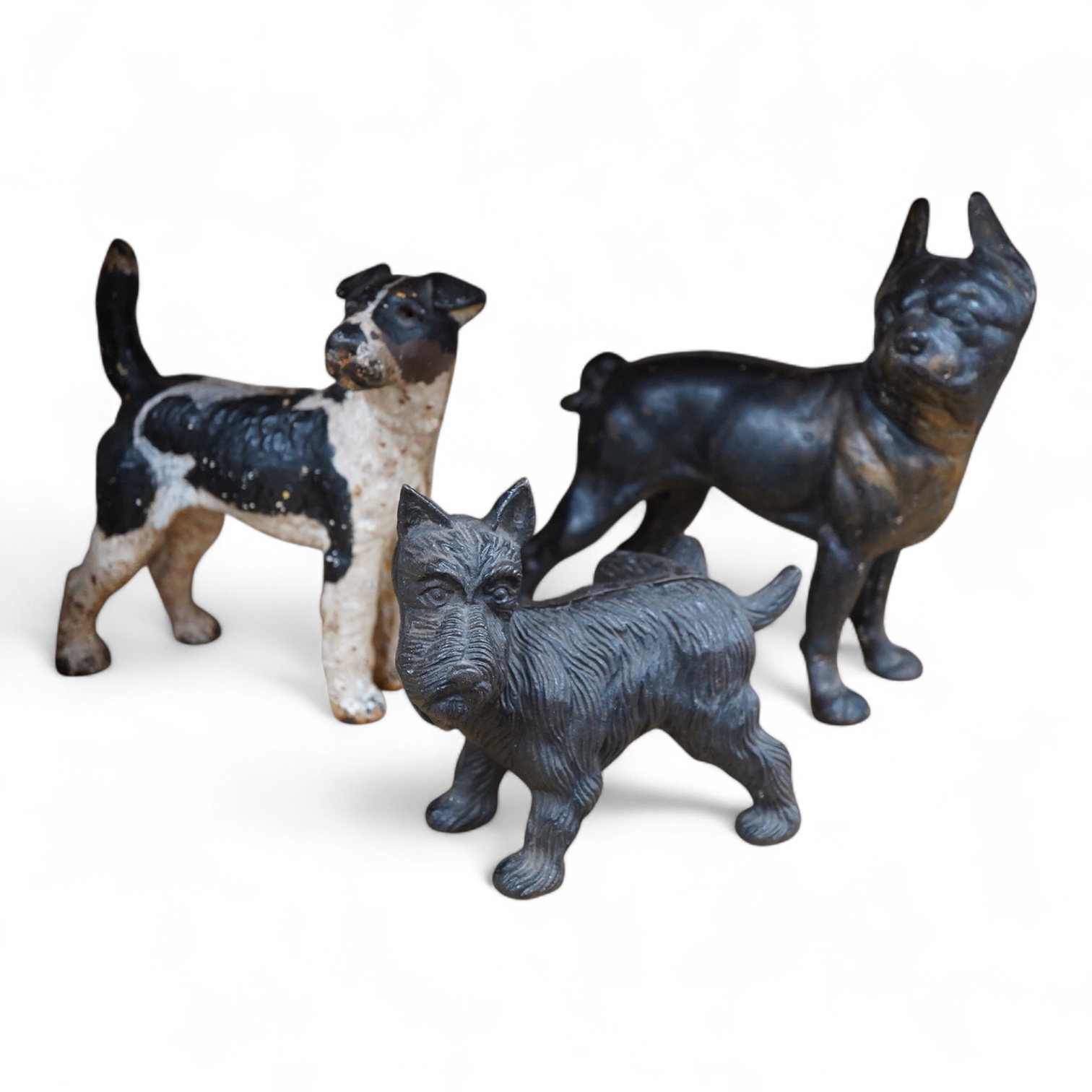 A group of three painted metal dogs, largest 25cm high x 23cm wide